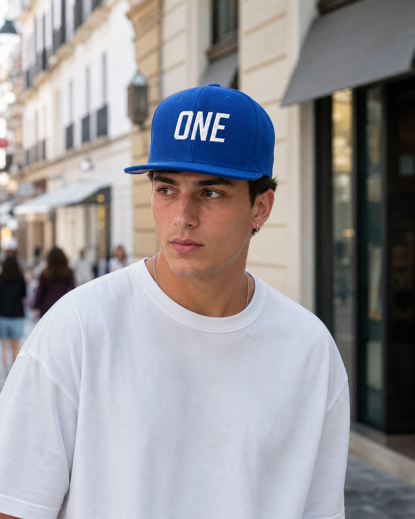 Gorra ONE Clean Blue azul real con bordado blanco, llevada por modelo en ciudad