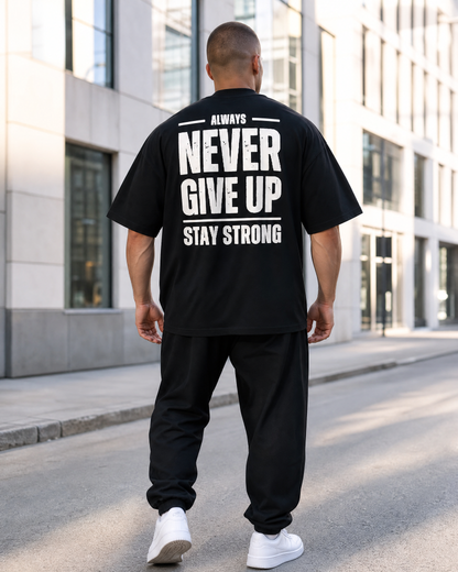 Modelo de espaldas vistiendo la camiseta Oversize Never Give Up ZHOMAX negra con estampado trasero Stay Strong